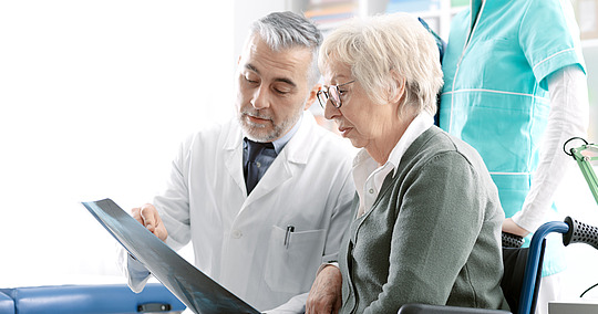 Arzt erklärt älterer Patientin Röntgenbild